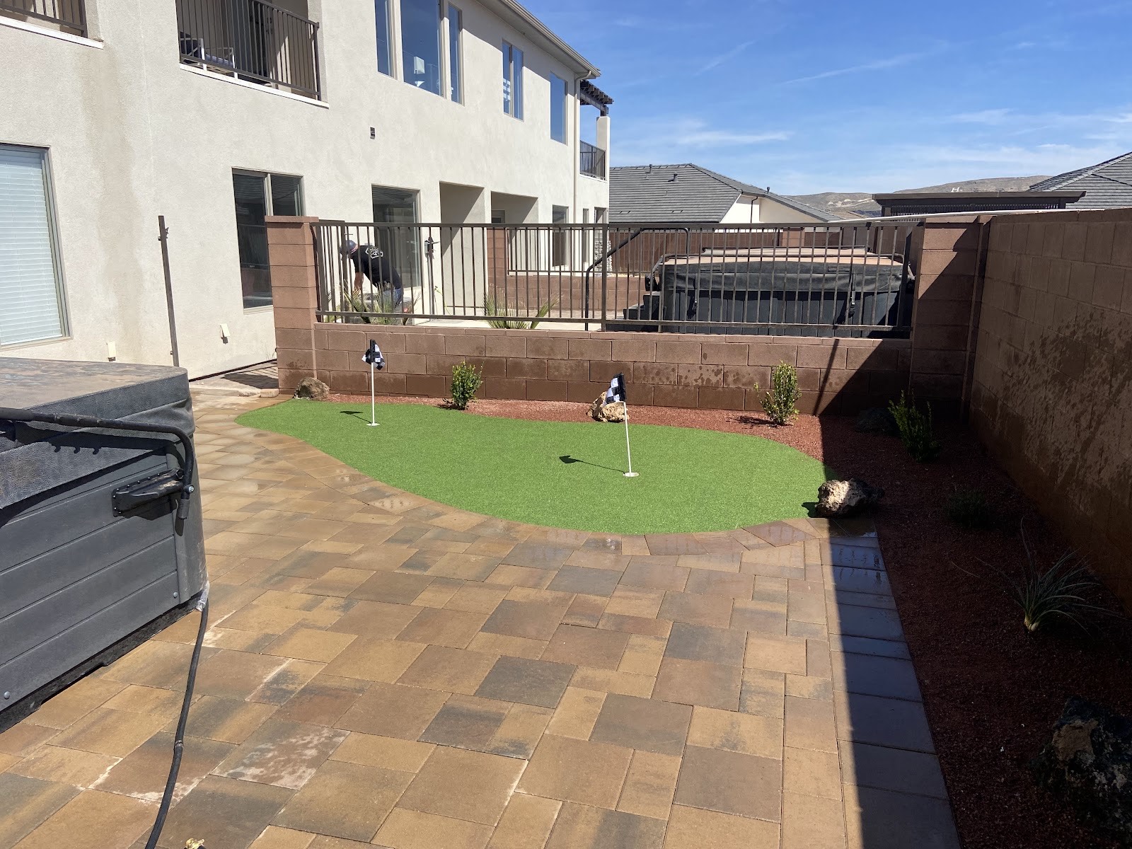 Backyard putting green, hot tub and paver patio installed by Elite Landscape