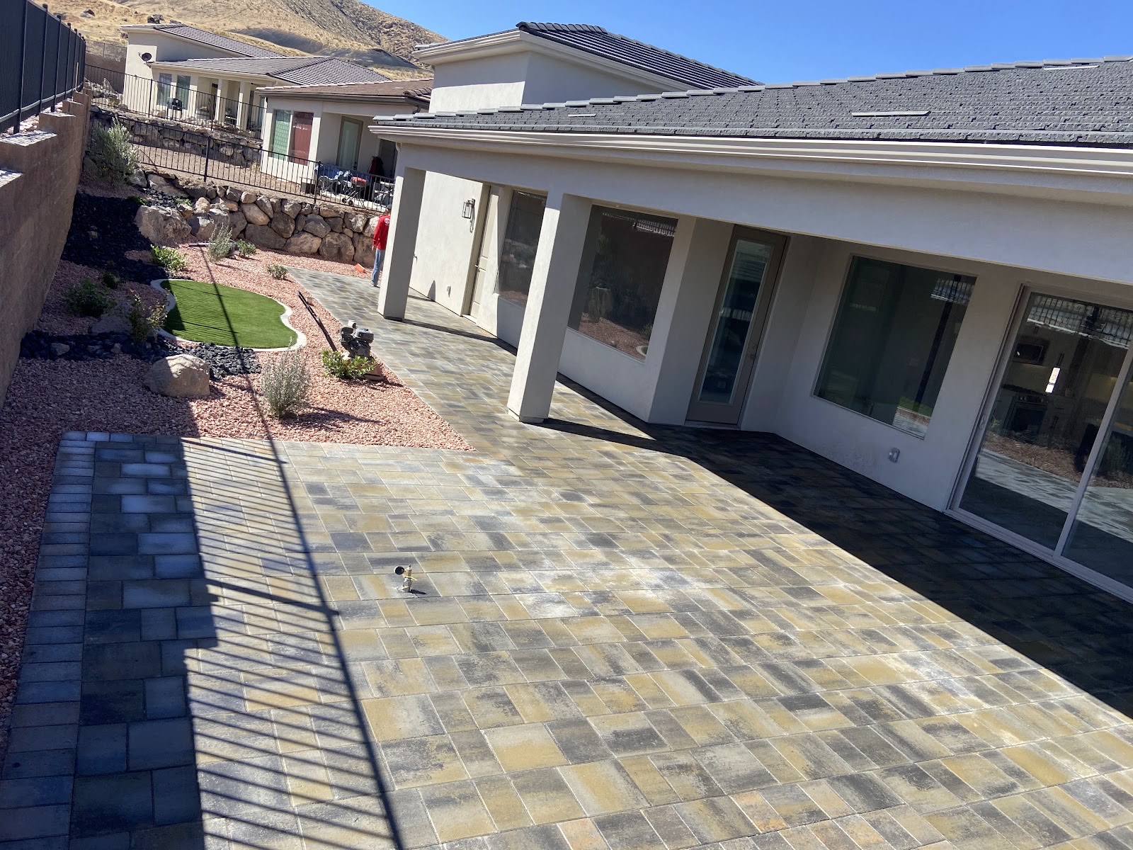 Expansive paver patio wrapping a St. George home against red-rock hills